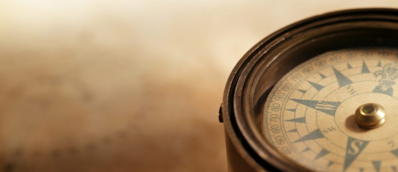 Coaching to find direction for professional women A compass on a faded sepia background